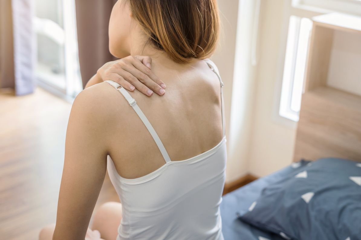 Frau hat Nackenschmerzen wegen ungeeigneter Matratze