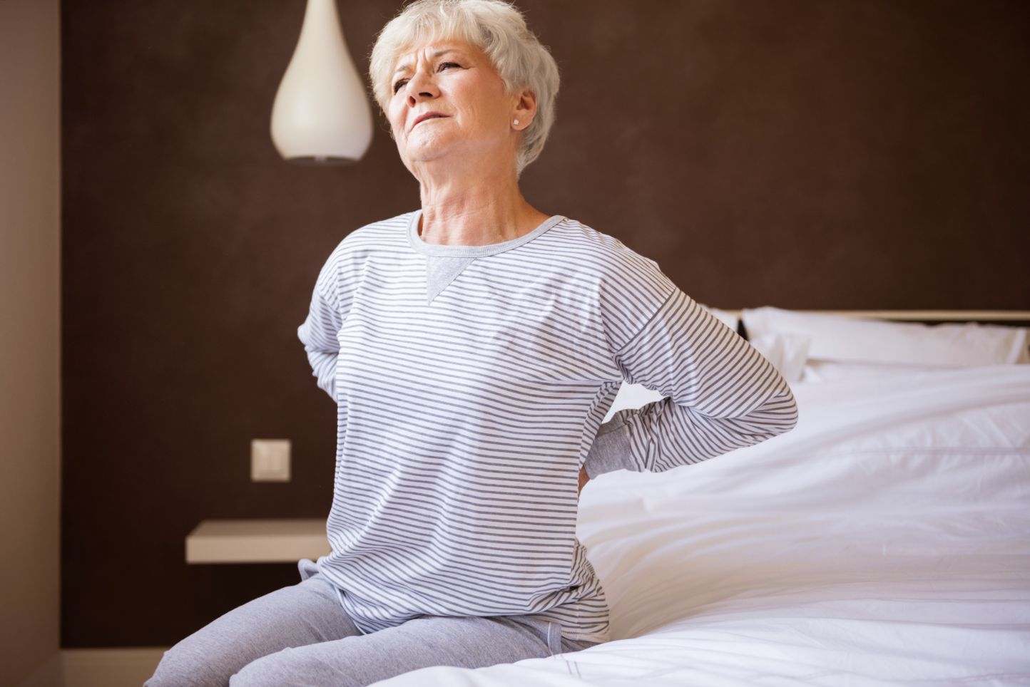 Frau auf Matratze mit Osteoporose