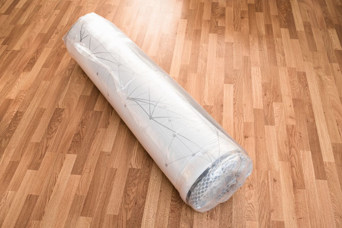 Eine Matratze liegt vakuumiert auf dem Fußboden